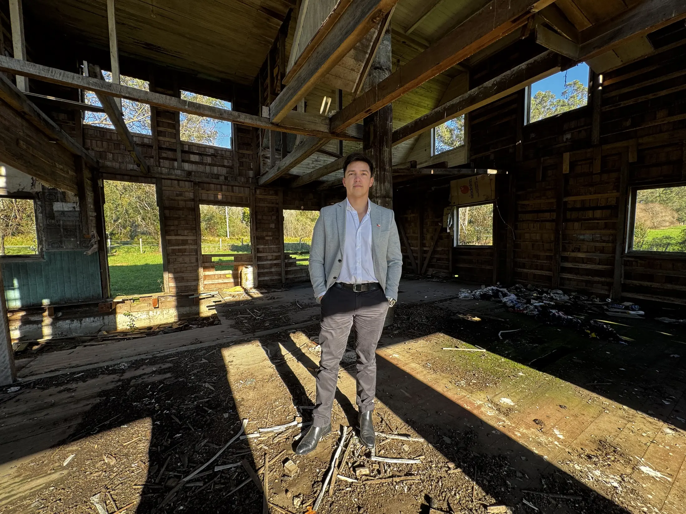 Carlos Aravena dentro de una estructura histórica de madera